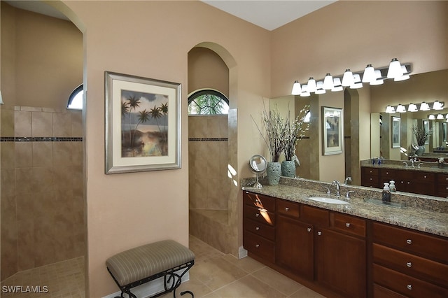 bathroom with a shower, plenty of natural light, tile patterned floors, and vanity