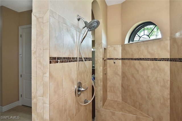 bathroom featuring tiled shower and tile patterned flooring