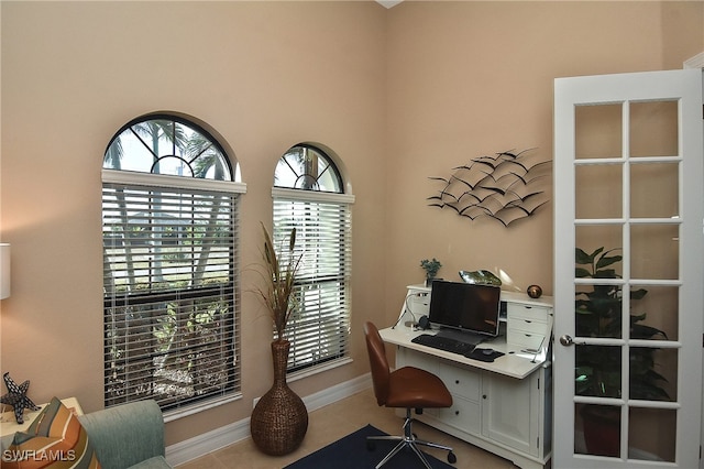 tiled office space featuring a healthy amount of sunlight and baseboards