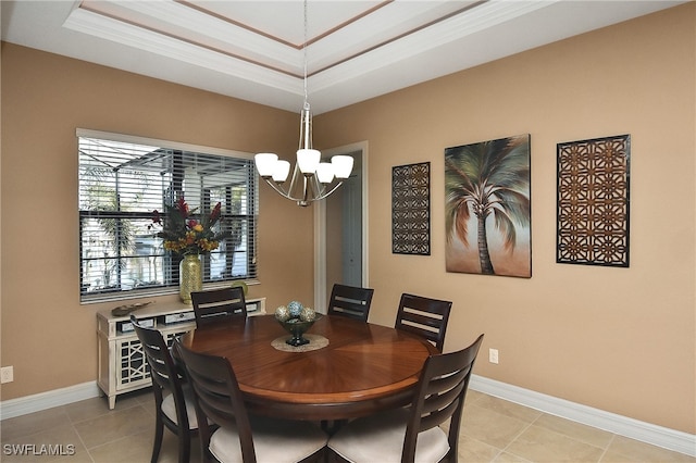 dining area with a raised ceiling, light tile patterned flooring, baseboards, an inviting chandelier, and ornamental molding