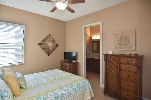 bedroom featuring a ceiling fan, a sink, ensuite bathroom, and light tile patterned floors