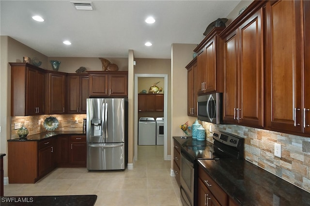 kitchen featuring stainless steel appliances, light tile patterned floors, separate washer and dryer, and backsplash