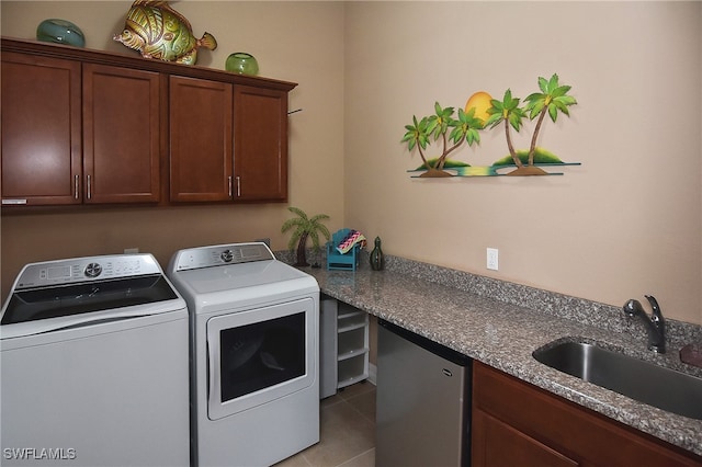 laundry room featuring sink, washing machine and clothes dryer, light tile patterned floors, and cabinets