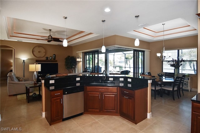 kitchen with pendant lighting, dishwasher, ceiling fan, a raised ceiling, and sink