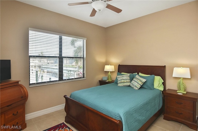 bedroom with ceiling fan, baseboards, and light tile patterned floors