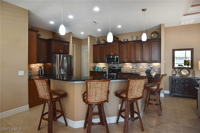 kitchen with a kitchen breakfast bar, visible vents, backsplash, and appliances with stainless steel finishes