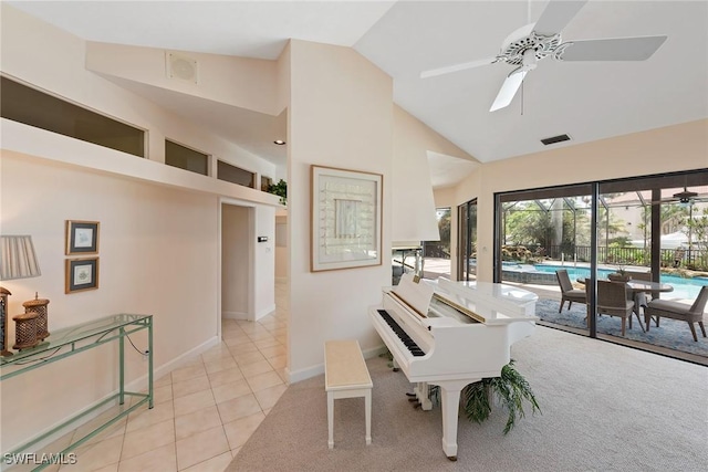 tiled dining space with high vaulted ceiling and ceiling fan