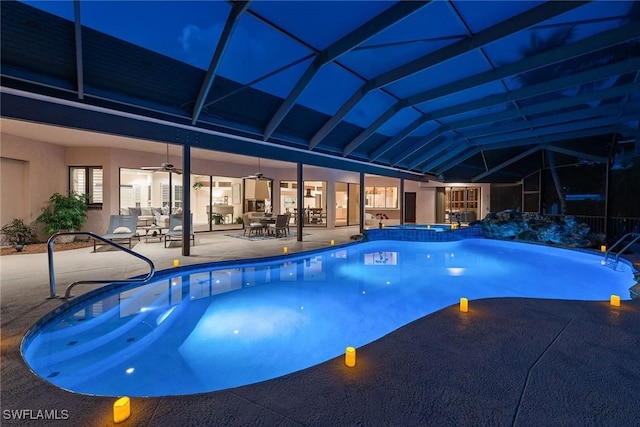 view of swimming pool with glass enclosure, ceiling fan, a patio, and an in ground hot tub