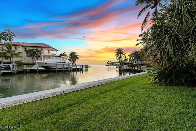 dock area with a lawn and a water view