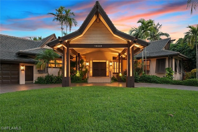 view of front of home with a yard and a garage