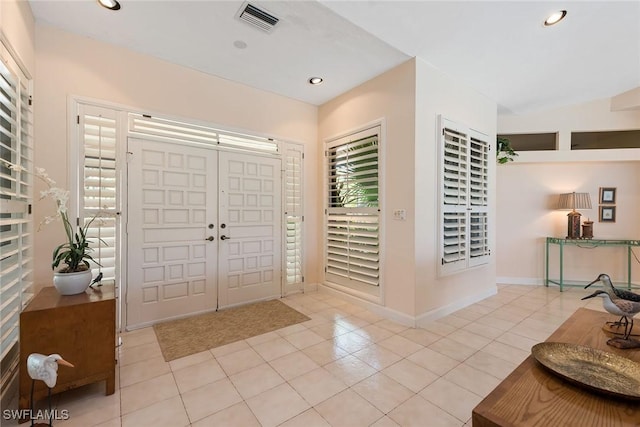 tiled foyer featuring vaulted ceiling