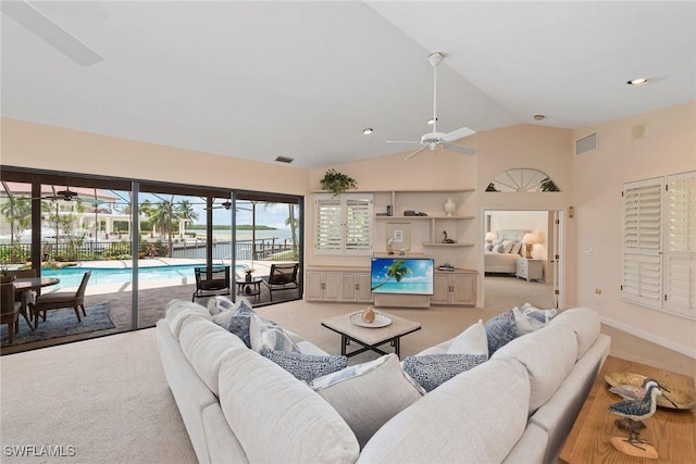 carpeted living room featuring ceiling fan and vaulted ceiling