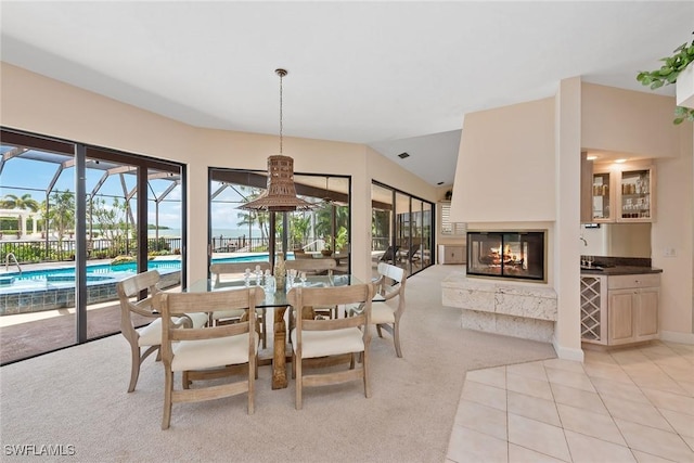 dining space featuring a multi sided fireplace and light carpet