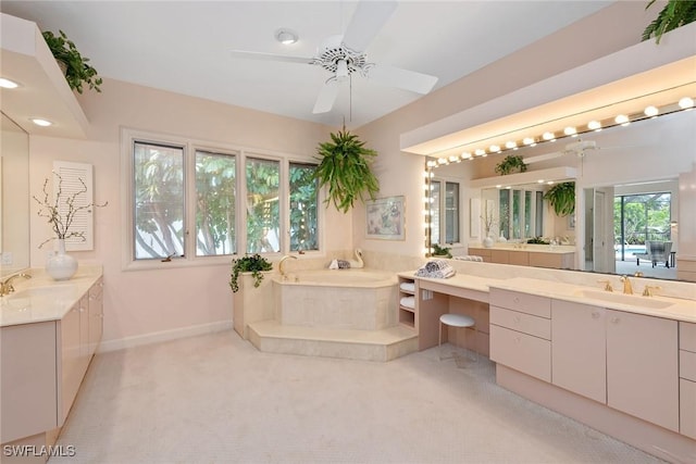 bathroom with ceiling fan, a tub to relax in, and vanity