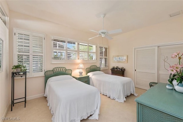 bedroom with ceiling fan, a closet, and light carpet