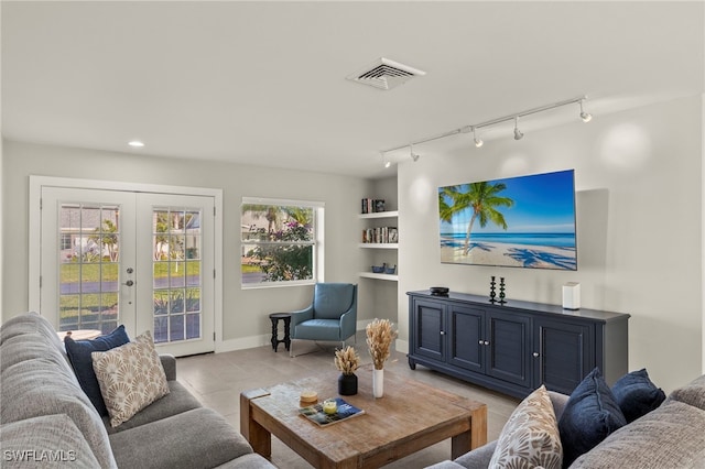 living room featuring french doors, light tile patterned floors, and built in features