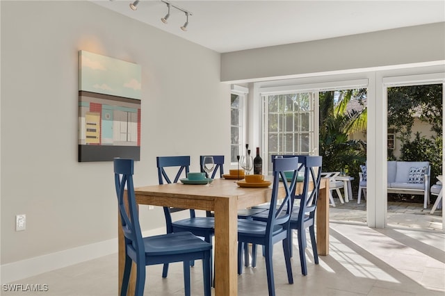 dining space featuring baseboards and track lighting