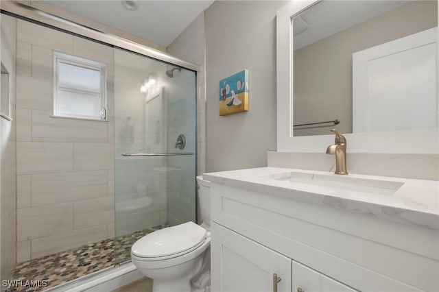 bathroom featuring vanity, toilet, and walk in shower