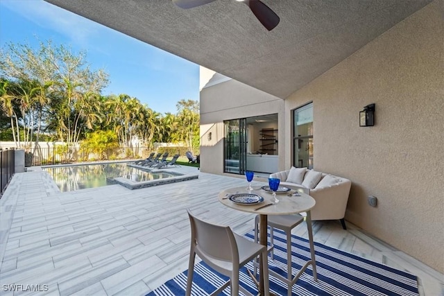 view of patio / terrace featuring ceiling fan and a pool with hot tub