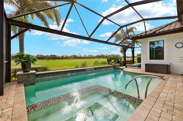 view of swimming pool with glass enclosure, an in ground hot tub, and a patio area