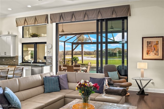 living room featuring hardwood / wood-style floors, a water view, and ornamental molding