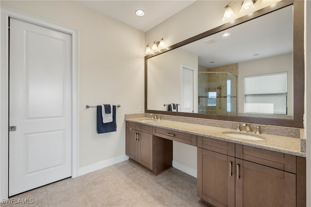 bathroom with a shower with door, vanity, and tile patterned flooring