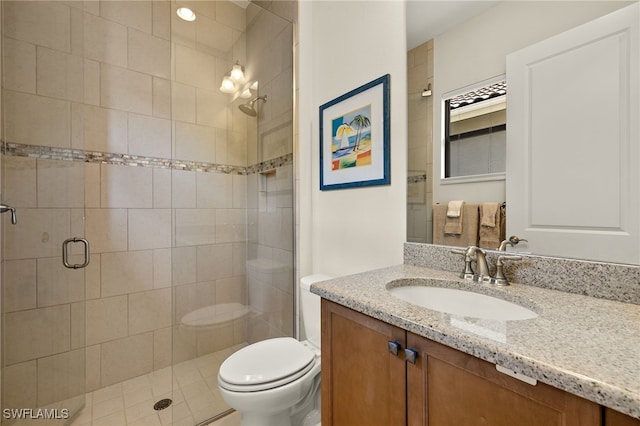 bathroom with vanity, toilet, and a shower with door