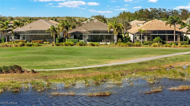 view of property's community featuring a lawn and a water view