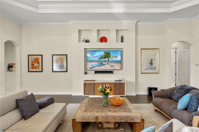 living room with hardwood / wood-style flooring, built in shelves, and ornamental molding