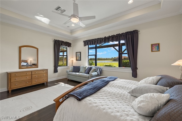 bedroom with ceiling fan, a raised ceiling, and dark wood-type flooring