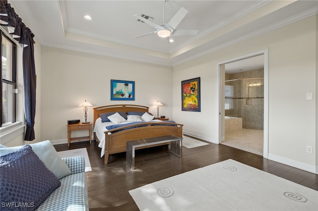 bedroom with dark hardwood / wood-style flooring, ensuite bathroom, ornamental molding, a tray ceiling, and ceiling fan