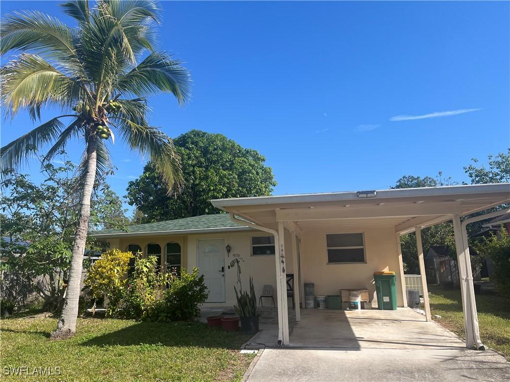 view of front of property featuring a carport and a front yard