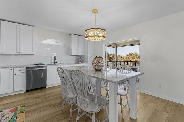 dining space featuring light hardwood / wood-style floors, an inviting chandelier, and sink