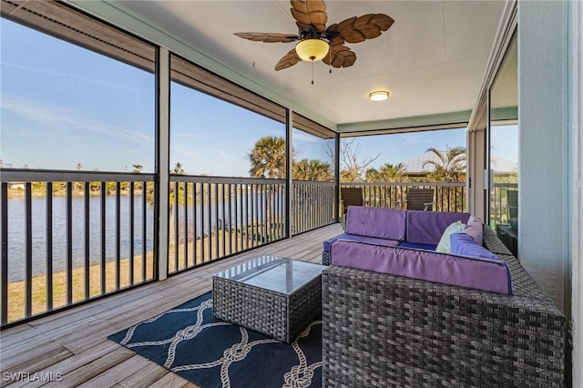 sunroom with ceiling fan, a water view, and a wealth of natural light