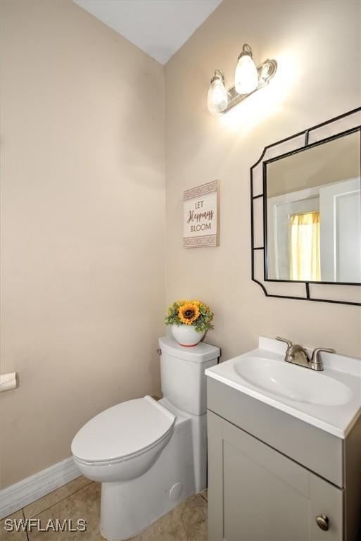 bathroom featuring vanity, tile patterned floors, and toilet