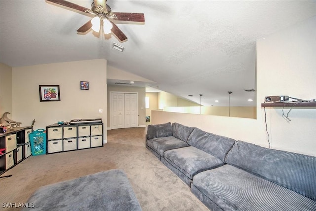 carpeted living room featuring ceiling fan, lofted ceiling, and a textured ceiling