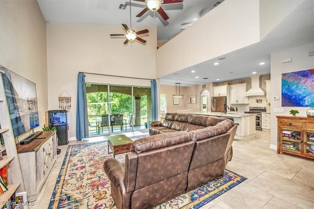 living room featuring ceiling fan and a towering ceiling