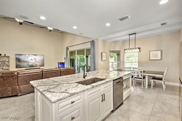 kitchen with sink, hanging light fixtures, stainless steel dishwasher, light stone countertops, and white cabinets