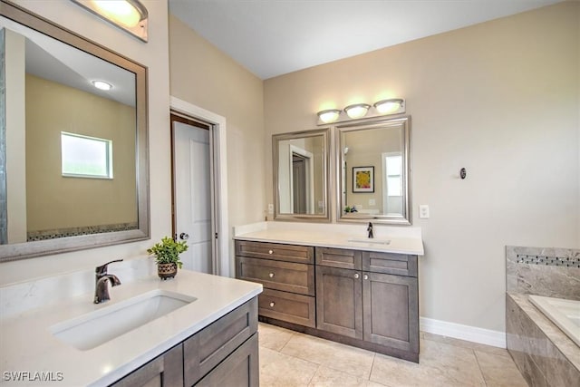 bathroom with vanity, tile patterned floors, and tiled bath