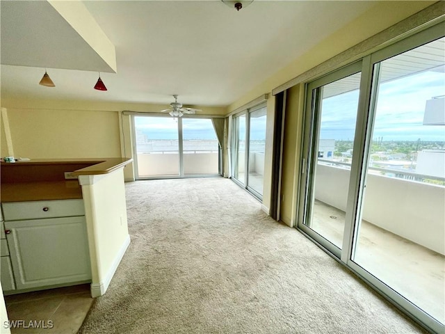 unfurnished living room featuring ceiling fan and light carpet