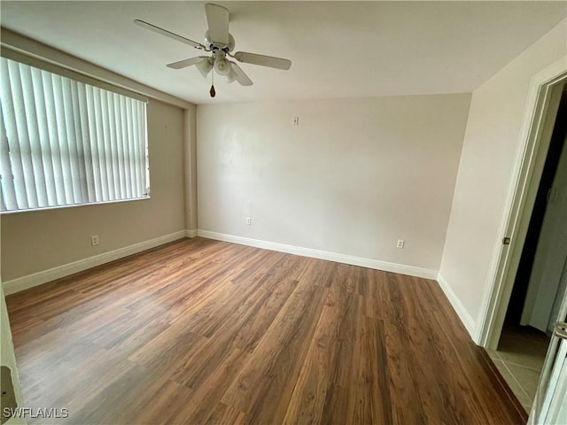 empty room featuring dark hardwood / wood-style flooring and ceiling fan