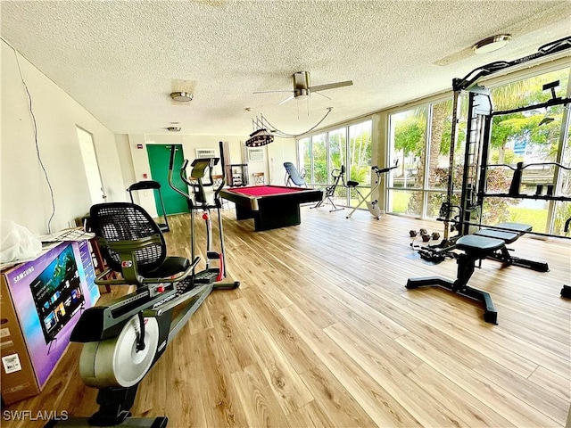 interior space with pool table, light wood-type flooring, ceiling fan, expansive windows, and a textured ceiling