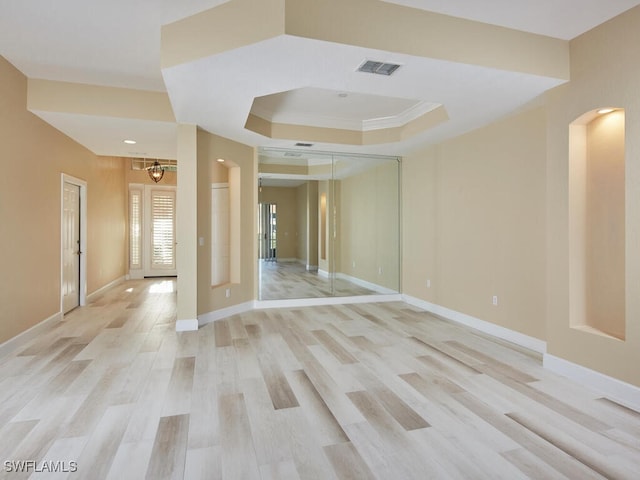 26916 Wyndhurst Ct Unit 102, Bonita Springs, FL 34134 - unfurnished room featuring visible vents, baseboards, a raised ceiling, arched walkways, and light wood-style flooring