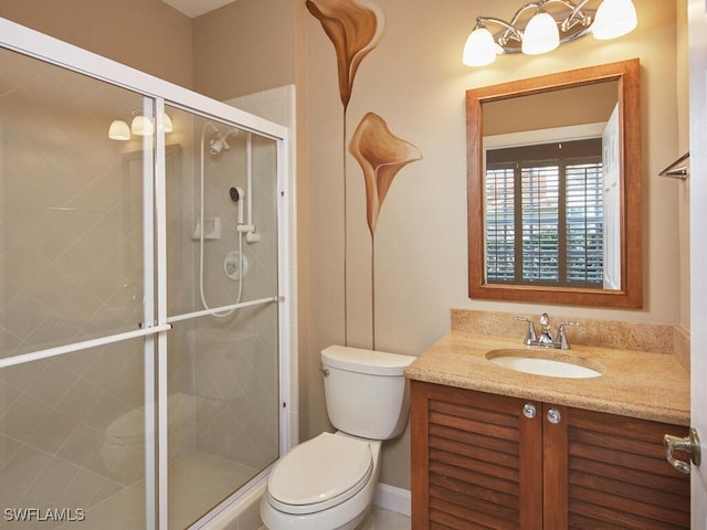 bathroom featuring vanity, toilet, and a shower with door