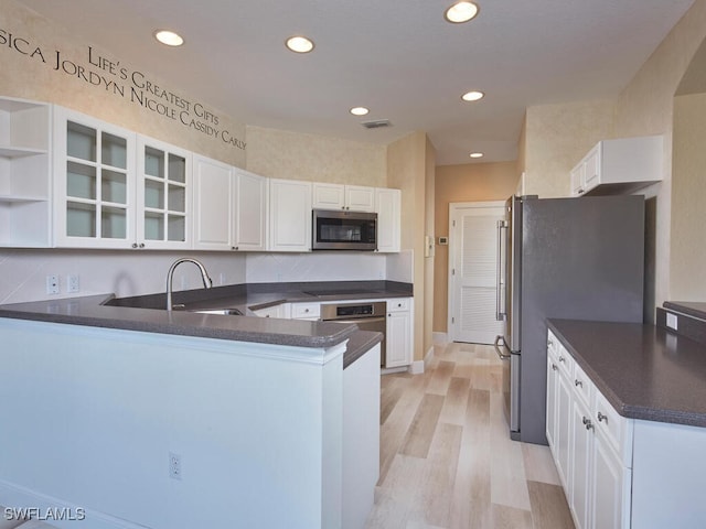 kitchen with white cabinetry, kitchen peninsula, sink, and appliances with stainless steel finishes