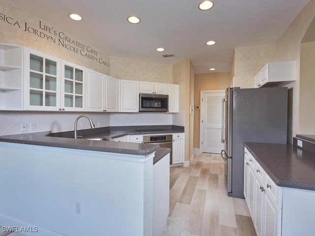 26916 Wyndhurst Ct Unit 102, Bonita Springs, FL 34134 - kitchen featuring a sink, appliances with stainless steel finishes, a peninsula, and dark countertops