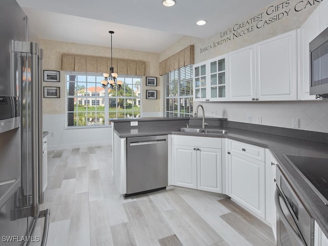 kitchen featuring sink, white cabinets, a notable chandelier, and appliances with stainless steel finishes