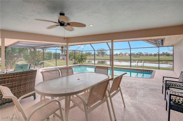 sunroom / solarium featuring ceiling fan, a water view, and a pool