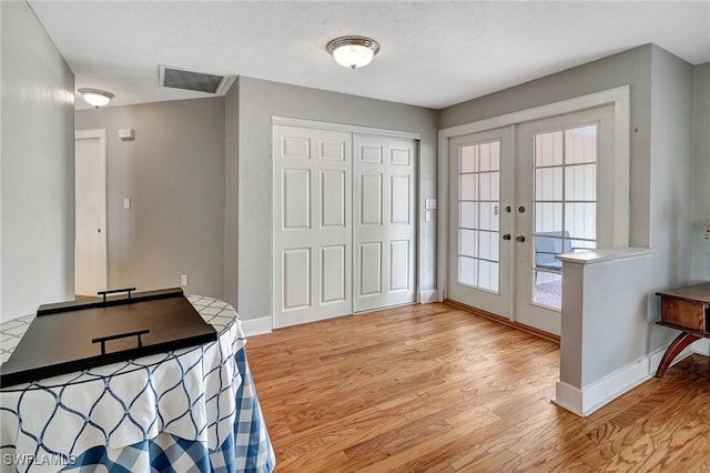 doorway with french doors and light wood-type flooring