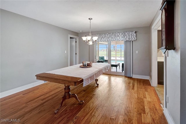 dining space featuring light hardwood / wood-style floors and a chandelier